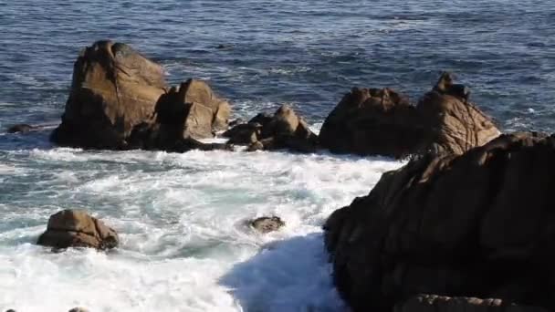 Hullámok megtörni a sziklás partvonal — Stock videók