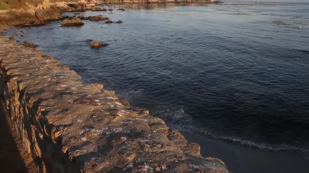 Calm ocean near houses on rocky shoreline — Stock Video