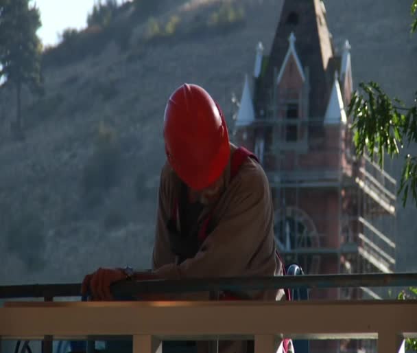 Bouwvakker met veiligheidshelm en klokkentoren — Stockvideo