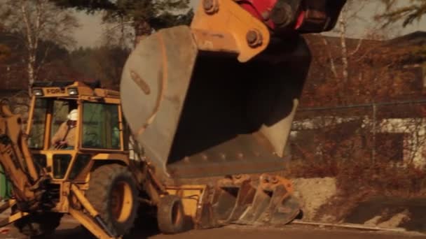 Trabalhador da construção civil opera retroescavadeira — Vídeo de Stock