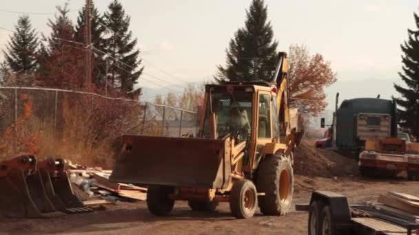 Backhoe rijden met dump truck — Stockvideo