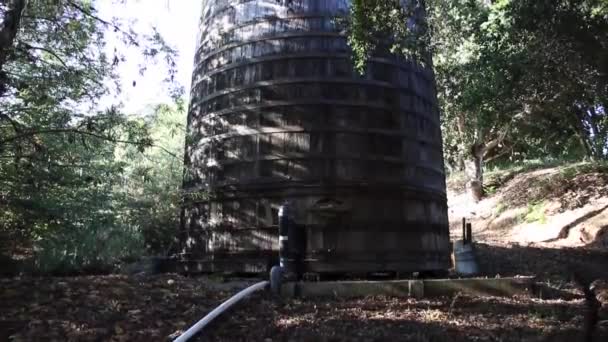 Oude houten watertank met bomen — Stockvideo
