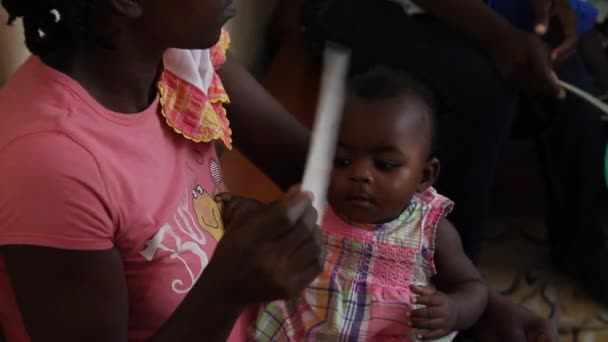 Мать, раздувающая маленького ребенка на Гаити — стоковое видео