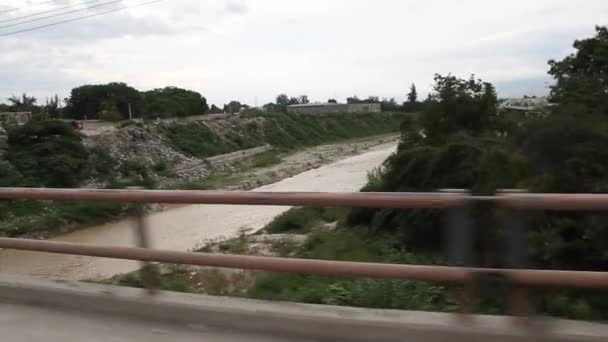 Rijden over een brug met een rivier in Haïti — Stockvideo