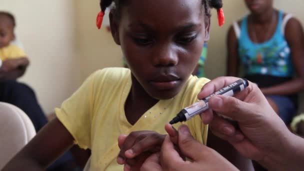 Kind erhält Fingernagelabdruck in Haiti — Stockvideo