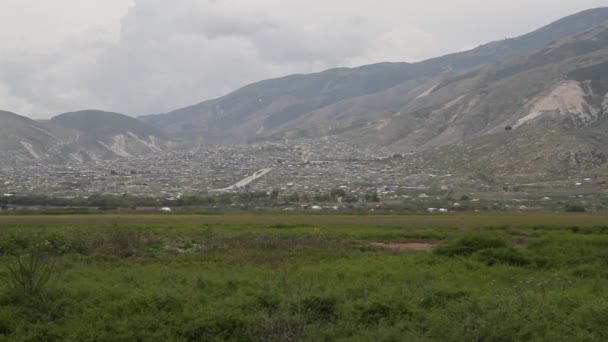 Ausgedehnte Barackensiedlungen und grüne Felder in Haiti — Stockvideo