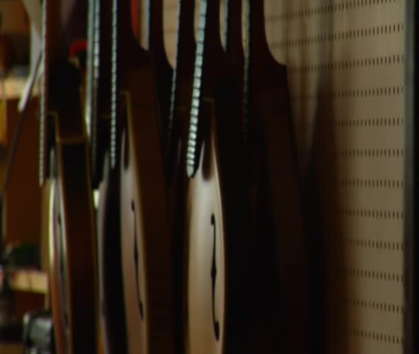 Shot of stringed instruments hanging on the wall — Stock Video