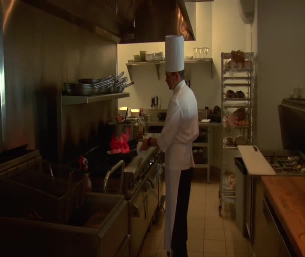 Chef con padella fiammeggiante sul fornello — Video Stock
