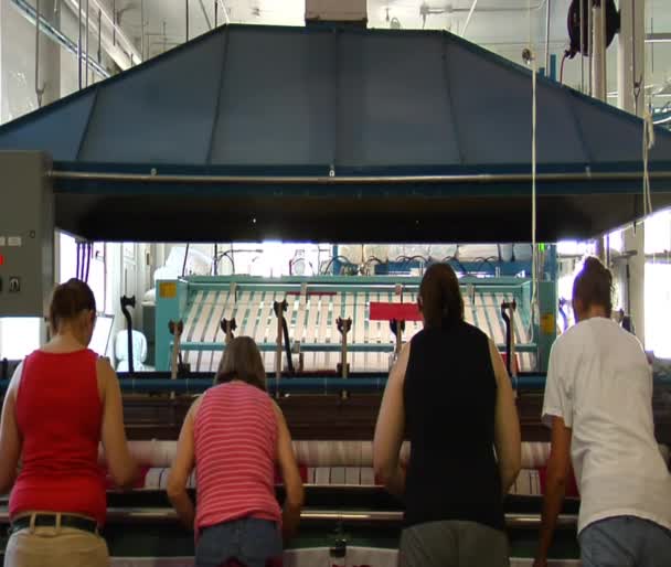 Vier dames opereren industriële strijken machine — Stockvideo