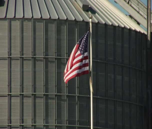 American flag waves in front of grain elevator — Stock Video