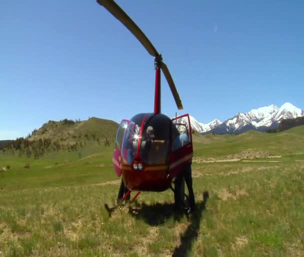 Férfiak turkálni piros helikopter leszállás után — Stock videók