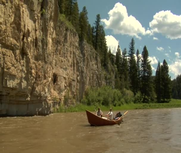 Flyfishing driftboat near rocky cliff — Stock Video