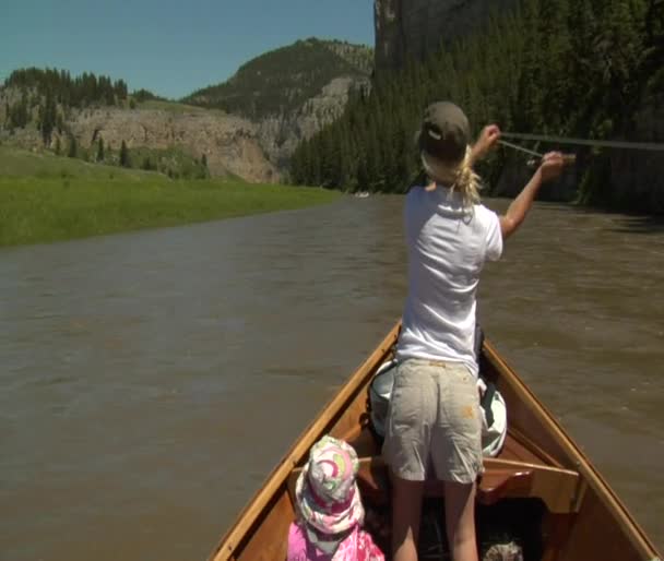Femme pêche à la mouche depuis bateau dérivant sur la rivière — Video