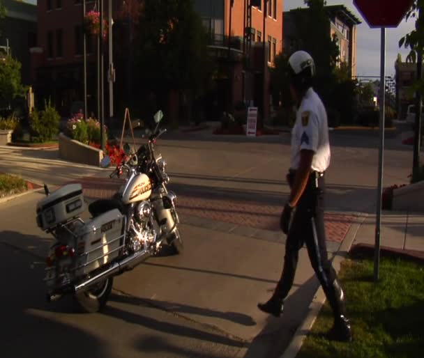 Policeman straddles motorcycle and drives off — Stock Video