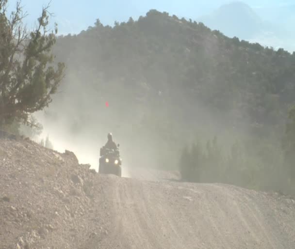 Cuatro ruedas con faros en carretera polvorienta — Vídeos de Stock