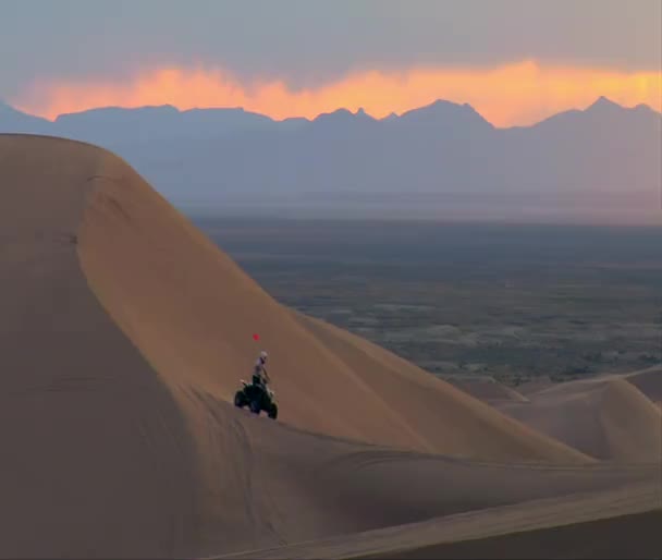 ATV αναβάτης σε αμμόλοφους και πανέμορφο βουνό ηλιοβασίλεμα — Αρχείο Βίντεο