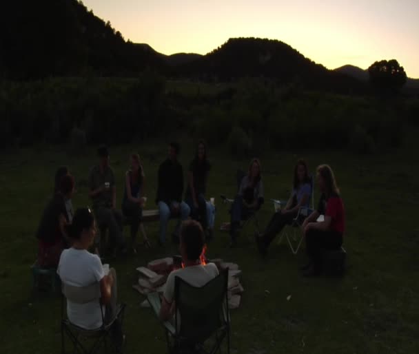 Groep zit rond het kampvuur — Stockvideo