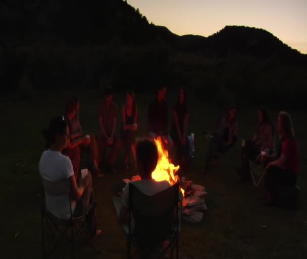 Groep zit rond het kampvuur — Stockvideo