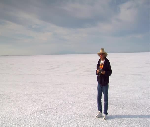Man with stopwatch and binoculars watches racers on Bonneville salt Flat — Stock Video