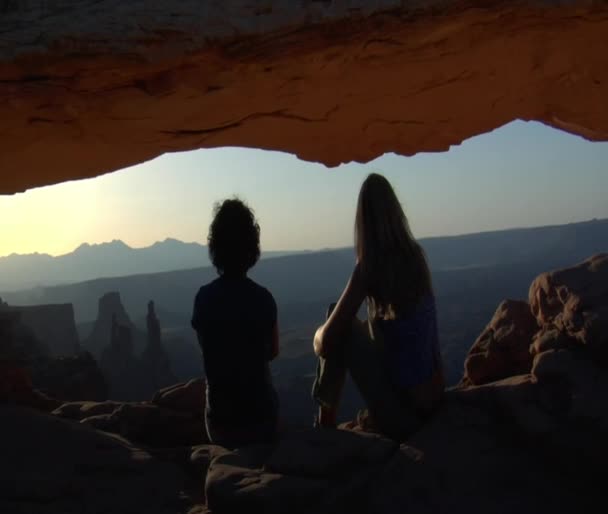 Ženy sedí pod Mesa arch — Stock video