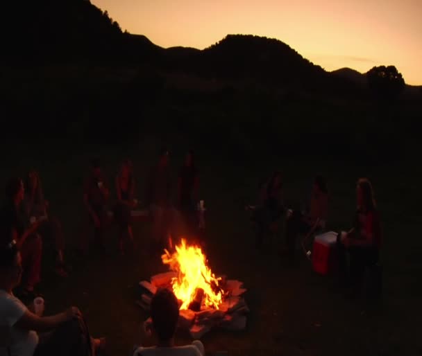 Grupa siedzi wokół ogniska — Wideo stockowe