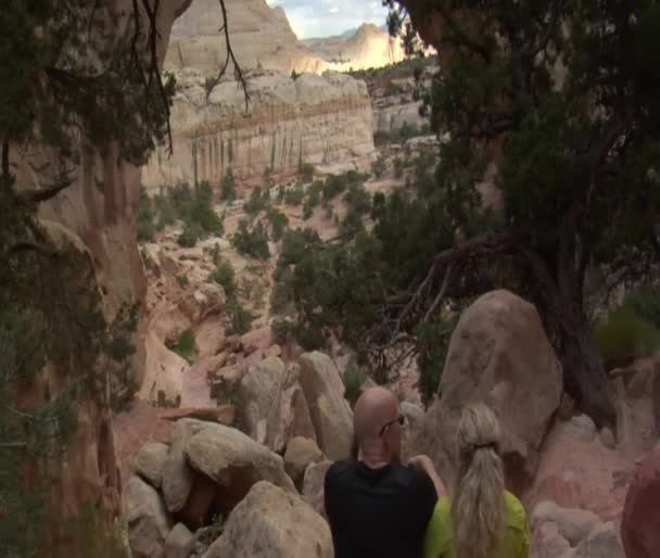 Coppia si siede sotto arco di arenaria — Video Stock