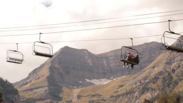 Los turistas en telesilla con la montaña en la distancia — Vídeos de Stock