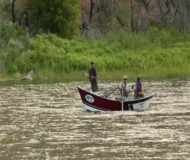 Trzech mężczyzn w flyfishing podróży łódź wiosło do pobytu stacjonarnego — Wideo stockowe