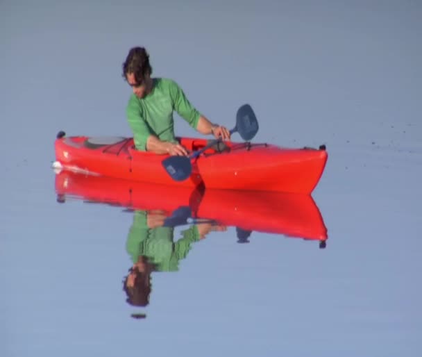 湖の上のオレンジ色のカヤックで男をパドルします。 — ストック動画