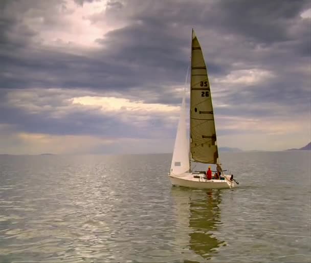 Una barca a vela naviga su un lago con le nuvole in alto — Video Stock