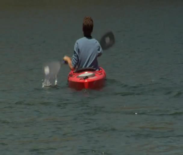 山の湖でカヤックを漕ぐ男性 — ストック動画