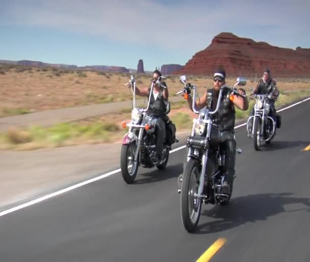 Trzech motocyklistów jazdę w dół autostrady pustyni — Wideo stockowe