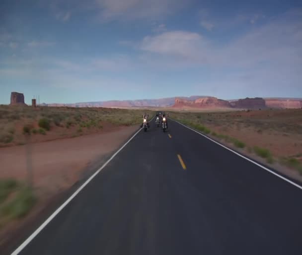 Three bikers speed on a scenic desert highway — Stock Video