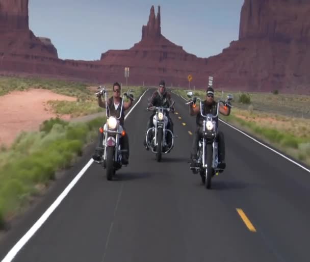 Tres motociclistas en la carretera del desierto, mesas detrás — Vídeos de Stock