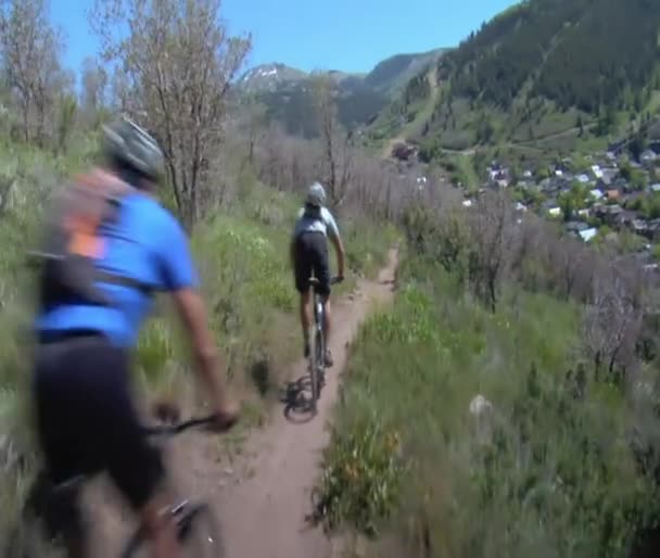 Mountainbikers vliegen stoffige zomer trail — Stockvideo
