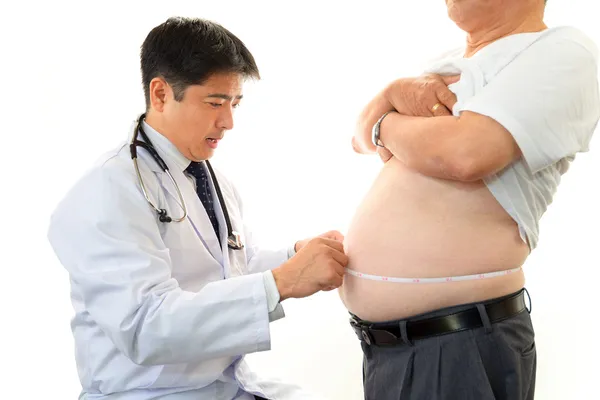 Medico serio che esamina l'obesità di un paziente Immagine Stock