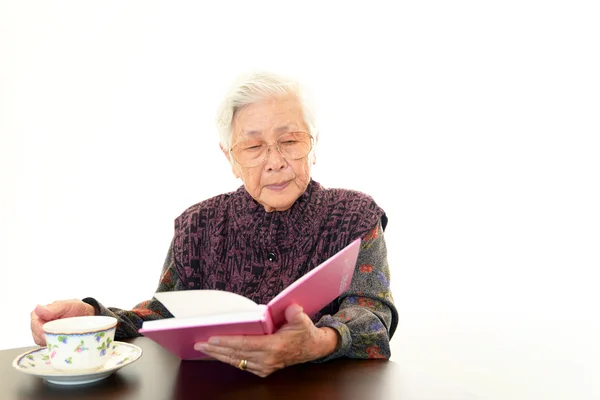 Oude vrouw haar boek lezen — Stockfoto