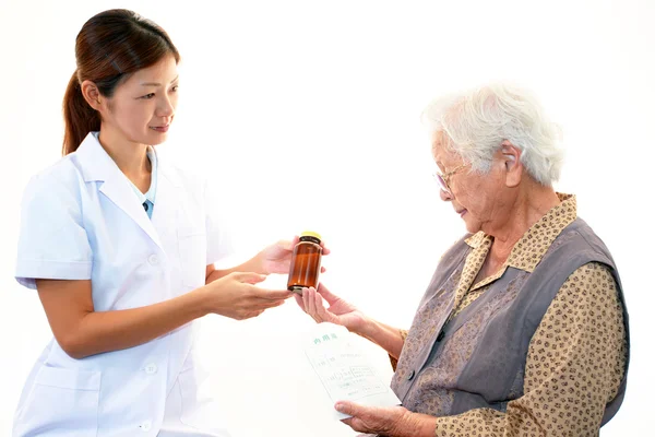 Pharmacienne souriante avec vieille femme — Photo
