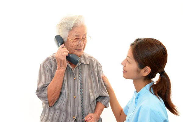 Vriendelijke verpleegster zorgt voor een oudere vrouw — Stockfoto