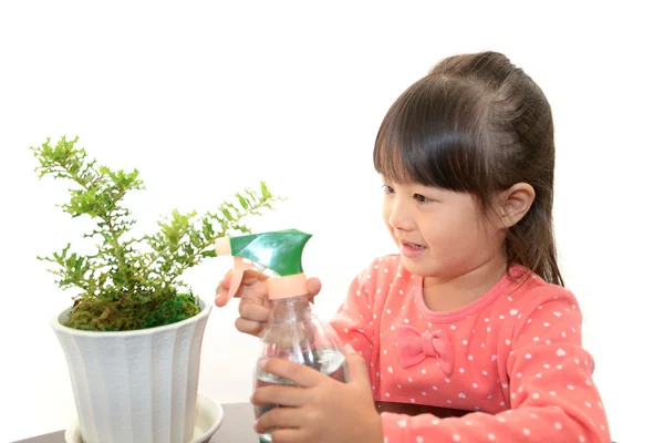 Smiling girl with plant — Stock Photo, Image