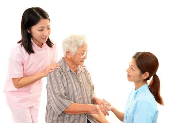 Enfermeira amigável cuida de uma mulher idosa — Fotografia de Stock