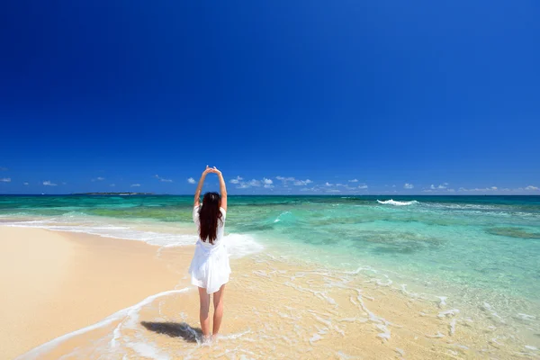 Молода жінка розтягується на пляжі — стокове фото