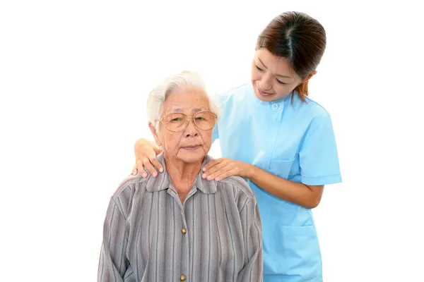 Amichevole infermiera si prende cura di una donna anziana — Foto Stock