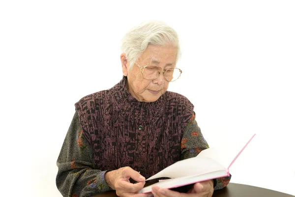 Old woman reading her book — Stock Photo, Image