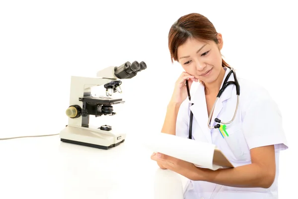 Läkare med en mikroskopisk undersökning — Stockfoto