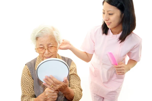 高齢者の女性を気遣うフレンドリーな看護師 — ストック写真