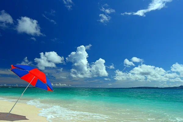 La playa y el paraguas de la playa de mediados de verano . — Foto de Stock