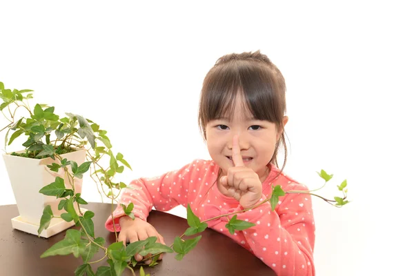 Sorridente ragazza asiatica con pianta — Foto Stock