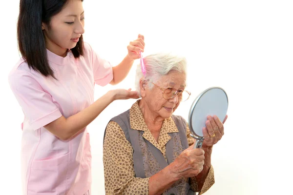 高齢者の女性を気遣うフレンドリーな看護師 — ストック写真