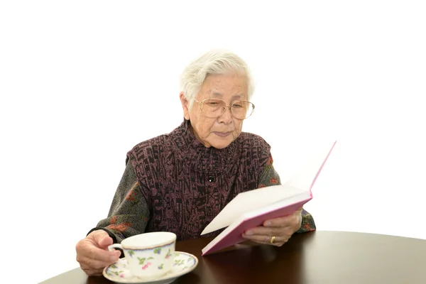 Vieille femme lisant son livre — Photo
